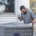 Home A technician inspects an outdoor HVAC unit for maintenance.
